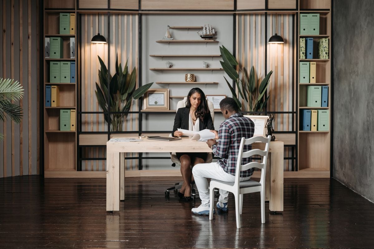 Advogada conversando com um cliente numa mesa de escritório