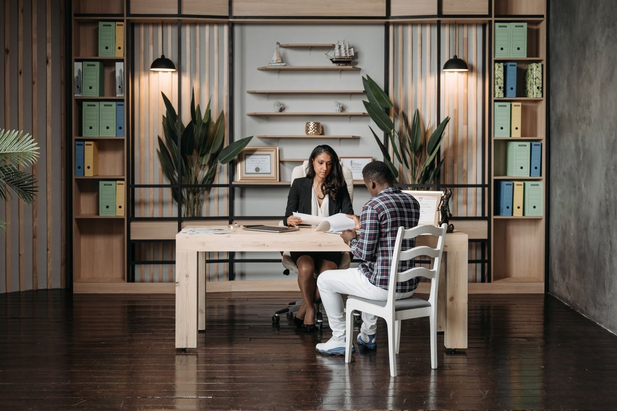 Advogada conversando com um cliente numa mesa de escritório