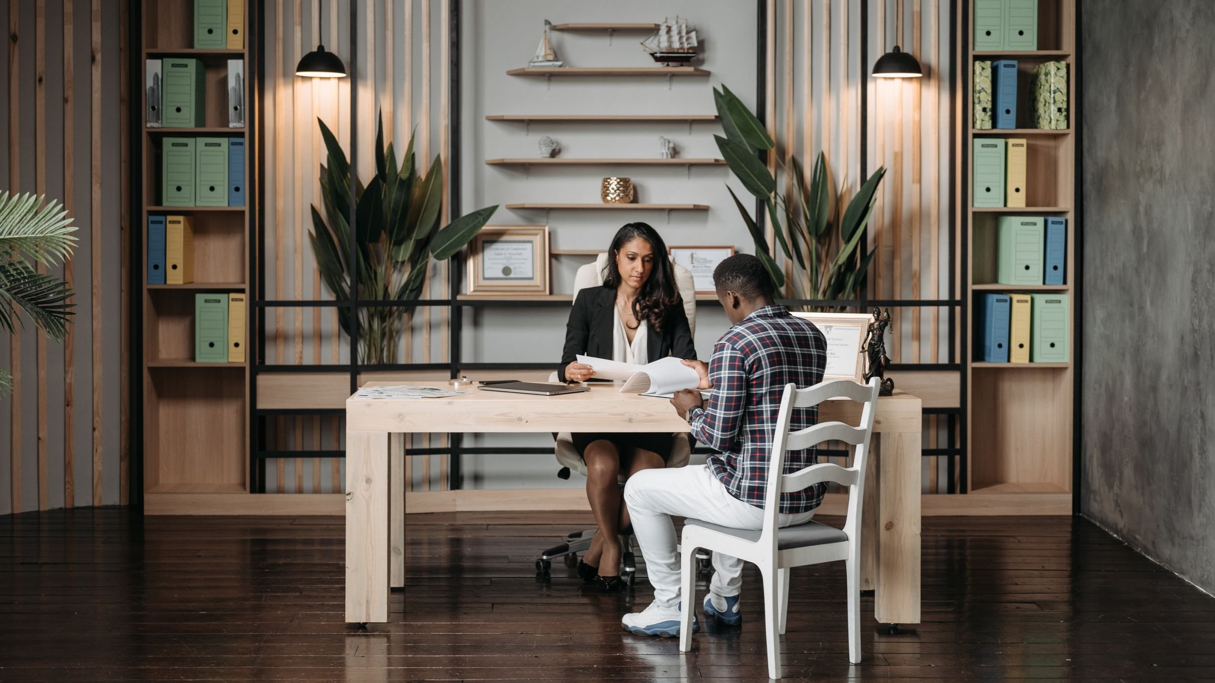 Advogada conversando com um cliente numa mesa de escritório